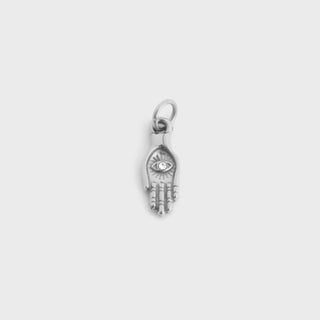 Silver hand charm with eye design on a light gray background