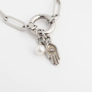 Silver bracelet with a hand charm and pearl on a white background