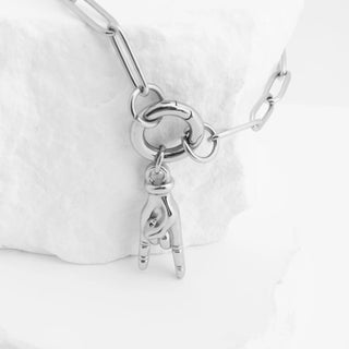 Silver bracelet with a small charm on a white background