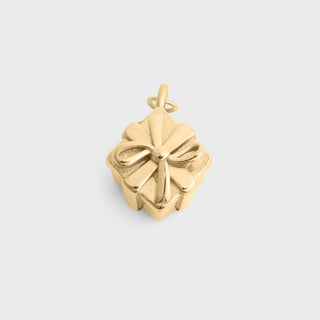Gold Present Charm with a bow design on a light gray background