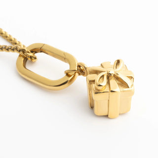 Gold necklace with a cube-shaped Present Charm on a white background