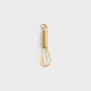 Gold whisk on a light gray background