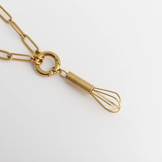 Gold necklace with a unique pendant on a white background