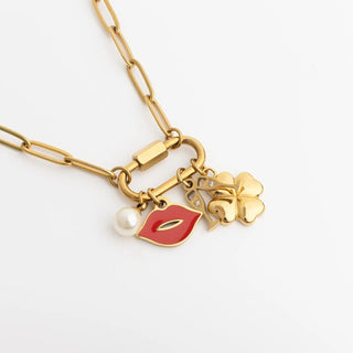 Gold necklace with charms on a white background