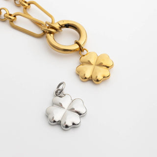 Gold and silver four-leaf clover pendants on a white background