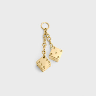 Gold dice-shaped earrings on a light gray background