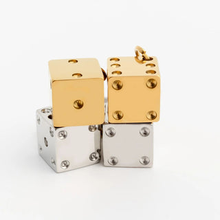 Gold and silver dice-shaped jewelry pieces on a white background