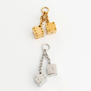 Gold and silver dice pendant on a white background