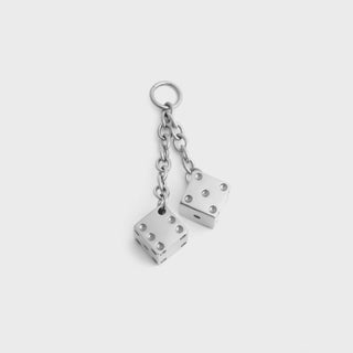 Silver dice pendant against a light grey background
