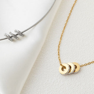 Gold necklace with circular pendants on a white surface