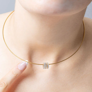 Gold necklace with a small spacer beads on a person's neck
