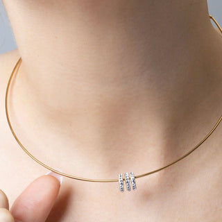 Gold necklace with spacer beads on a person's neck
