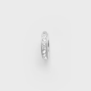 Silver spacer beads with clear stones on a light gray background