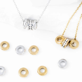 Gold and silver necklaces with spacer beads on a white background