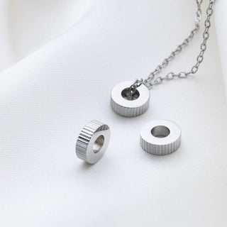 Silver necklace with fluted spacer beads on a white background