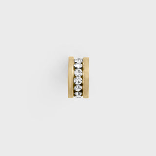Gold spacer bead with embedded crystals on a light gray background