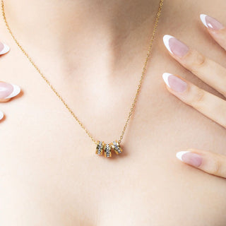 Gold necklace with a small spacer beads on a person's neck
