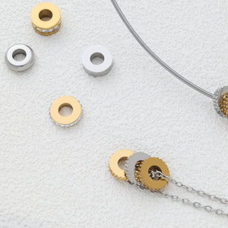 Gold and silver textured spacer beads on a textured white surface