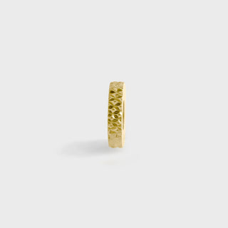 Gold textured spacer bead on a light gray background