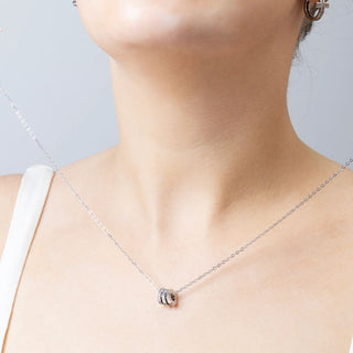 Silver necklace with textured spacer beads on a neutral background