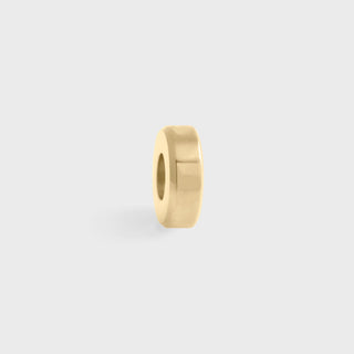 Gold spacer bead on a light gray background