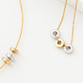 Gold and silver necklace with spacer beads on a white background