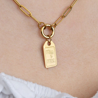 Gold necklace with a tag pendant on a person's neck