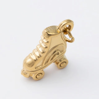 Gold roller skate charm on a white background