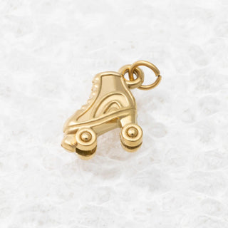 Gold roller skate charm on a white background