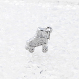 Silver roller skate charm on a white marble background