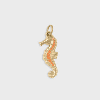 Gold seahorse pendant with coral-colored stripe on a light gray background