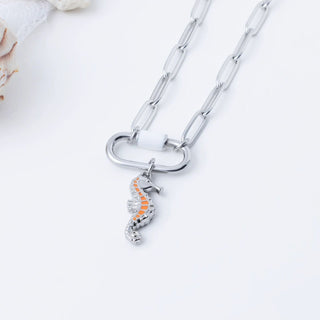 Silver necklace with a seahorse pendant on a light background