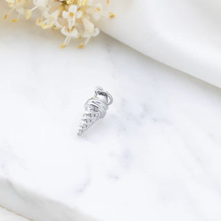 Silver charm resembling an ice cream cone on a white background with flowers.