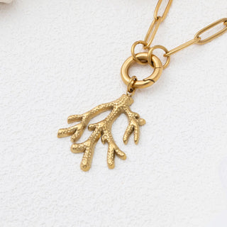 Gold necklace with a coral branch pendant on a white background