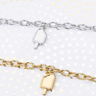Two bracelets with popsicle charm pendants on a white background with gold polka dots.