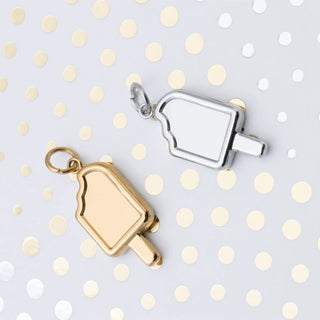 Gold and silver popsicle charm on a polka dot background