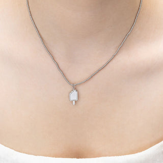 Silver necklace with a pendant on a person's neck