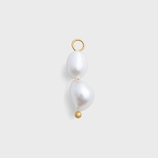 Pearl charm with gold hook on a light gray background