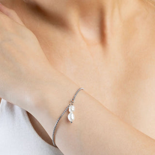 Pearl bracelet on a person's wrist with a soft background