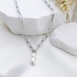 Silver chain necklace with a pearl pendant on a white background