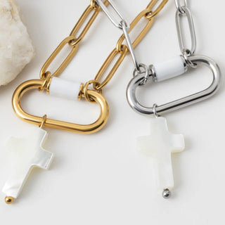 Two chain necklaces with cross-shaped pendants on a light background