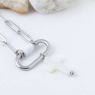 Silver cross-shaped pendant on a white background