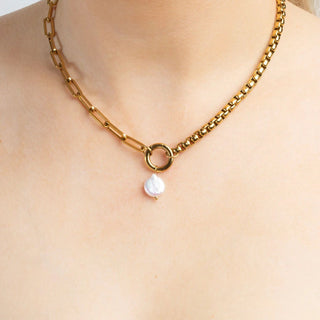 Gold chain necklace with a pearl pendant on a person's neck
