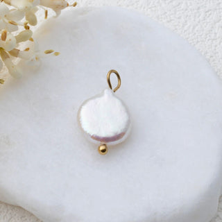 Pearl pendant with gold accents on a white background