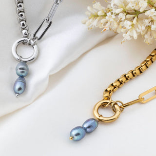 Two necklaces with black pearls on a white background