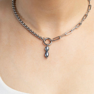 Necklace with a pendant on a person's neck against a neutral background