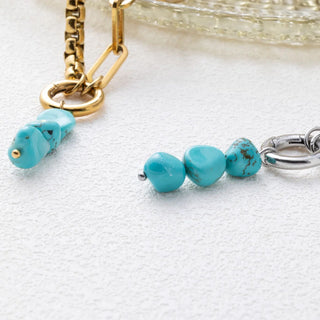 Turquoise beaded pendant with gold and silver chain on a white background