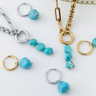 Jewelry set with turquoise beads and gold and silver chains on a white background
