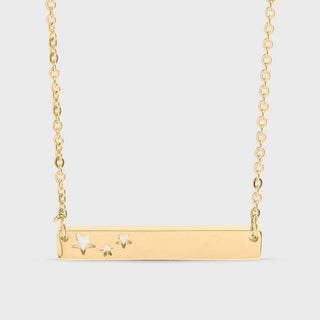 Gold necklace with star designs on a light gray background