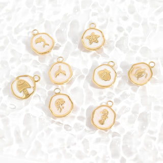 Gold charms with various designs on a white textured background